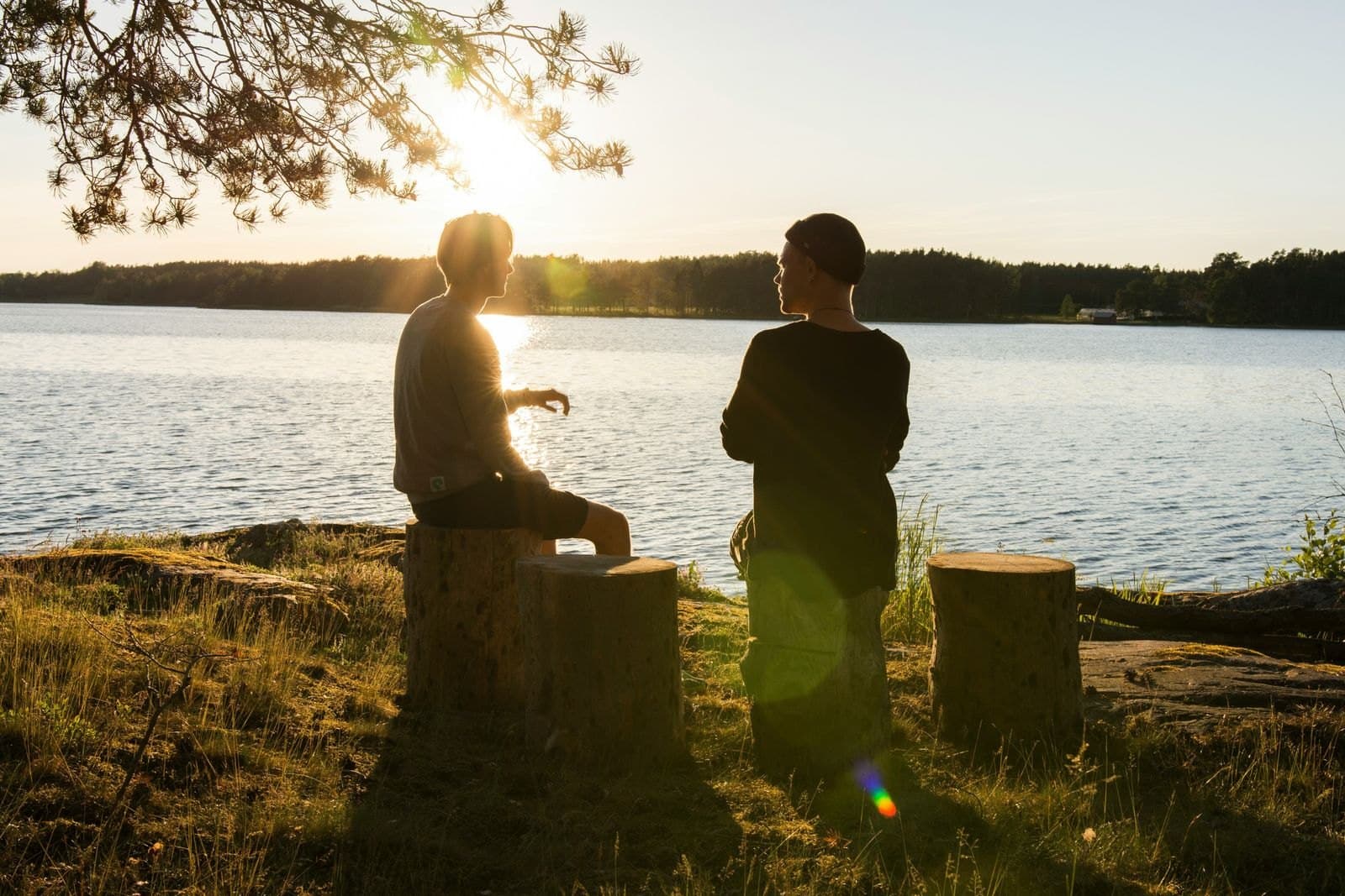 To personer ved vannkanten i kveldslys